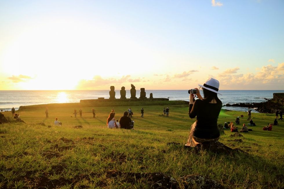 turystka na tle olbrzymow skalnych moai na wyspie wielkanocnej