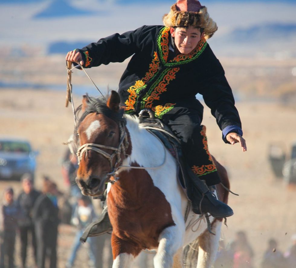 plemienskie plemiona poruszajace sie na koniach na mongolskich stepach